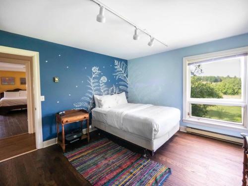1 dormitorio con cama y pared azul en Berkshire Vacation Rentals: Private Oasis: 16 Acres Pool, en Chatham