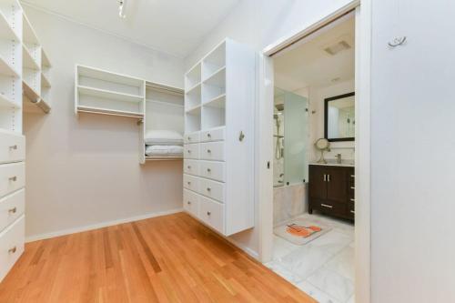a bedroom with white cabinets and a mirror at South End Hospitality: Downtown Crossing Large Lofted Condo Location in Boston