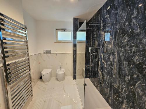 baño con aseo y pared de cristal en GIARDINO DEI PRINCIPI en Citta' Sant'Angelo