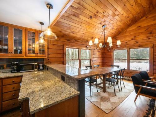 a kitchen with a large island in a log cabin at Berkshire Vacation Rentals: Private Cabin On Over 12 Acres Of Woods in Becket