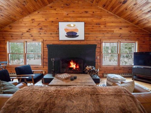 a living room with a fireplace in a log cabin at Berkshire Vacation Rentals: Private Cabin On Over 12 Acres Of Woods in Becket