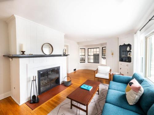 a living room with a blue couch and a fireplace at Berkshire Vacation Rentals: Chic Pittsfield Home With A View in Pittsfield