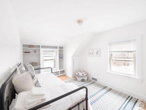 a white living room with a couch and a window at Berkshire Vacation Rentals: Chic Pittsfield Home With A View in Pittsfield