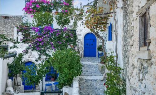 a blue door on a white building with flowers at Rustic House in the country in Kritsá