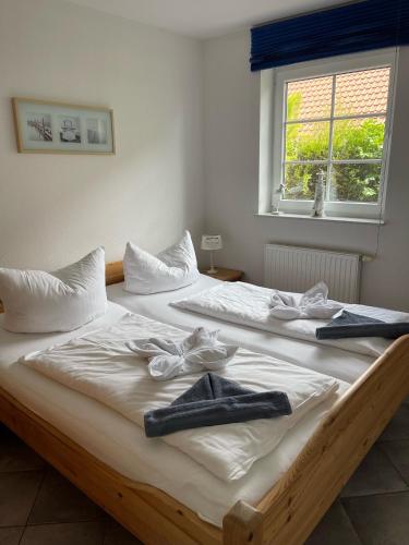 two beds in a room with towels on them at Deichbrise in Greetsiel