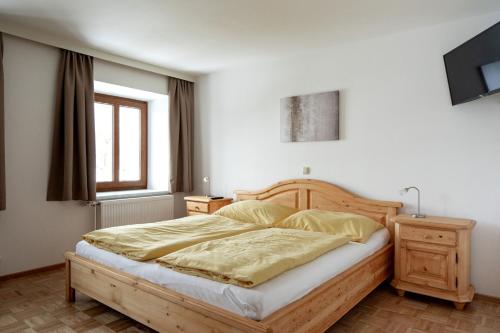 a bedroom with a bed with a wooden bed frame at Grabmayrhof in Kremsmünster