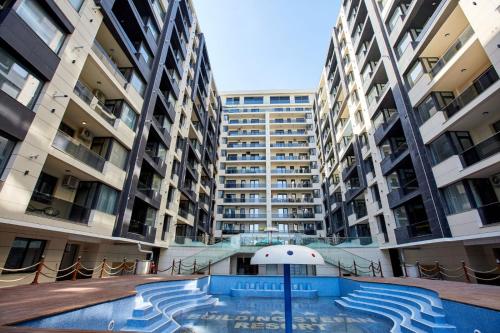 an apartment complex with a swimming pool in front of buildings at Apartamente by R S in Năvodari