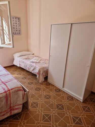 ein Schlafzimmer mit einem Schrank und einem Bett sowie Fliesenboden in der Unterkunft Room via Monte 14 in Reggio nell'Emilia