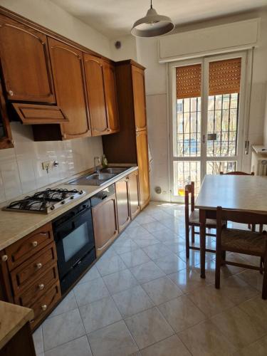 eine Küche mit Holzschränken, einem Tisch und einem Herd in der Unterkunft Room via Monte 14 in Reggio nell'Emilia