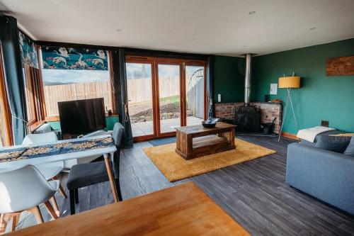 a living room with a couch and a table at Woodpecker Lodge- A Pet Friendly Rural Retreat in Callington