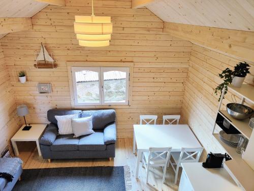 a living room with a couch and a table at Tiny houses Liv & Lea in Listerby