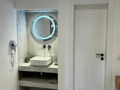 a bathroom with a sink and a mirror on the wall at Potami Seashell in Himare