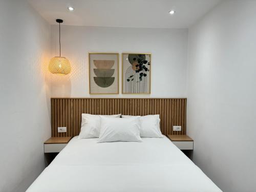 a bedroom with a large white bed and two pictures at Potami Seashell in Himare