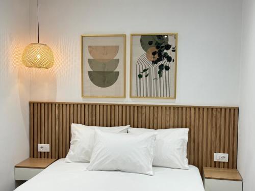 a bedroom with a bed with white pillows and two pictures at Potami Seashell in Himare