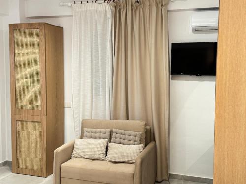 a living room with a chair and a television at Potami Seashell in Himare