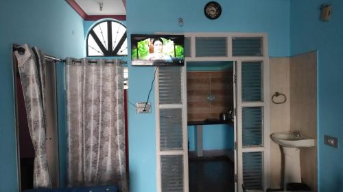 Cette chambre comprend une télévision et une salle de bains pourvue d'une fenêtre. dans l'établissement Dreamy bungalow 2BHK apartment, à Mysore