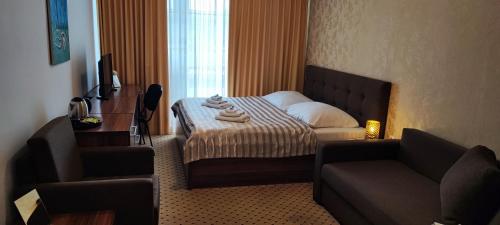a hotel room with a bed and a couch at Hotel Merkur in Kaluža
