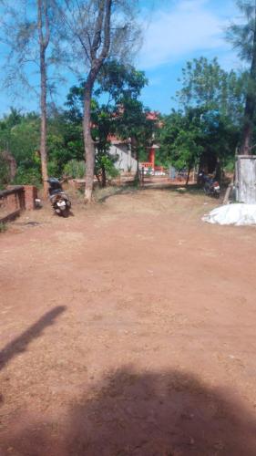 a dirt road with a motorcycle parked in a field at CLASSIC ANAND Bungalow-Blossom Suite, Tarkarli Road, Malvan in Malvan