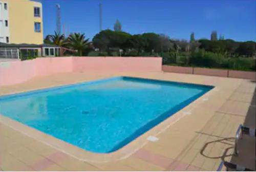 une grande piscine avec de l'eau bleue dans l'établissement Duplex Cap d'Agde vue mer avec piscine, au Cap d'Agde