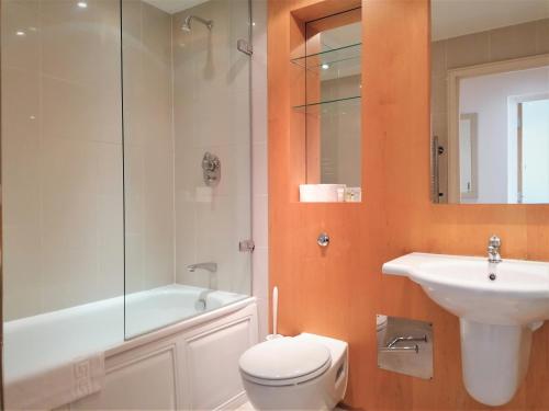 a bathroom with a toilet and a sink and a shower at Still Life Tower Hill Executive in London