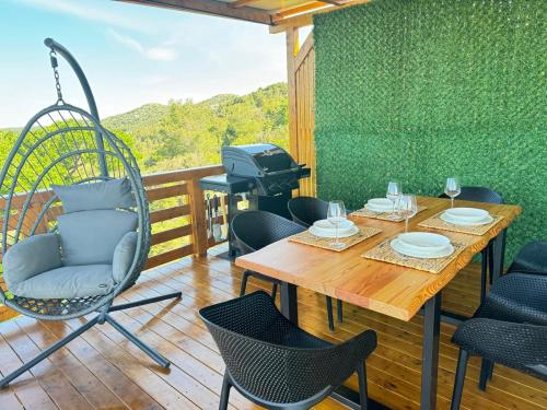 a patio with a table and chairs and a grill at d-view Premium Mobile Home - panoramic seaview - 150 m from beach, free parking in Drage