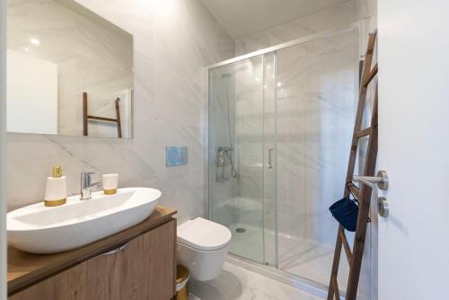 a white bathroom with a sink and a shower at Chic Porto Hideaway: Pool & Garden in Porto