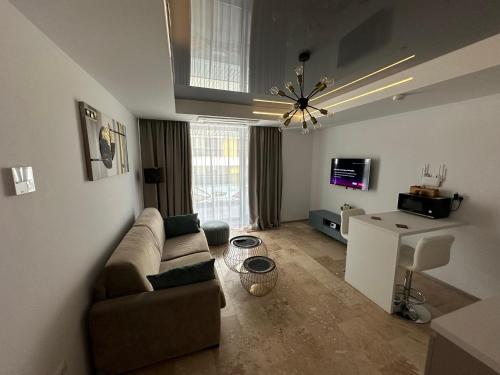 a living room with a couch and a television at Astria by the Sea Apartment in Olimp