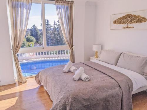 1 dormitorio con 1 cama grande y 2 toallas. en Panoramic views & pool. 4 mins to beach, en Santa Fe de los Boliches