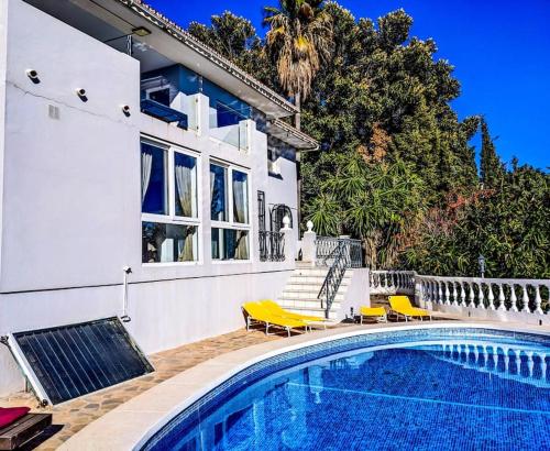 una casa con piscina frente a una casa en Panoramic views & pool. 4 mins to beach, en Santa Fe de los Boliches