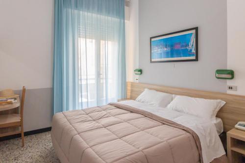 una camera con un grande letto e una finestra di Abc Hotel a Rimini