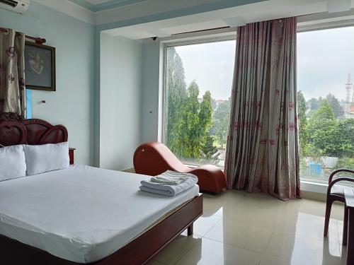 een slaapkamer met een bed en een groot raam bij Nhà nghỉ thảo ngân in Bình Mỹ