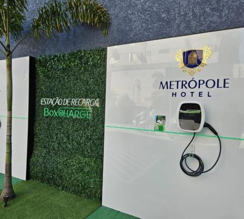 a sign for a metropole hotel with a phone at Hotel Metrópole Maringá in Maringá