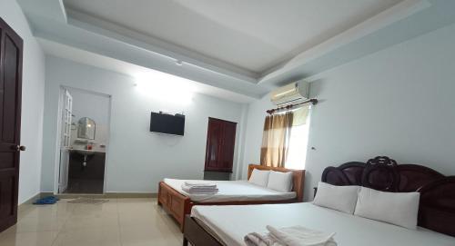 a hotel room with two beds and a window at Nhà nghỉ thảo ngân in Bình Mỹ