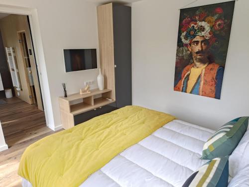 1 dormitorio con 1 cama con una pintura en la pared en KERLAGATU en Quimper