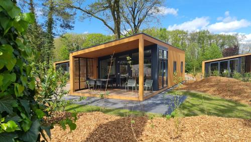 Cette petite maison dispose de murs en verre et d'une terrasse. dans l'établissement Lodgepark 't Vechtdal, à Dalfsen