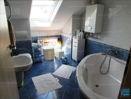 a bathroom with a white tub and a sink at Budapest Residence in Vác