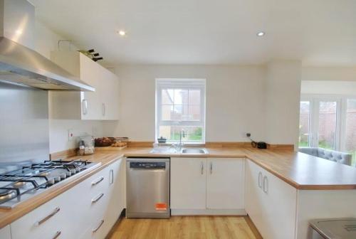 a kitchen with white cabinets and a stove top oven at Cozy Casa: A Home Away from Home 