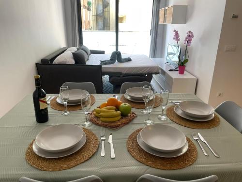 - une table à manger avec des assiettes et des fruits dans l'établissement Apartament Mar Beach Lloret, à Lloret de Mar