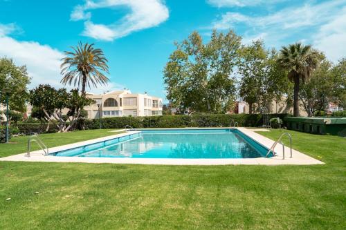 a swimming pool in a yard with trees and a house at Sunstay Seaview Guadalmar in Málaga