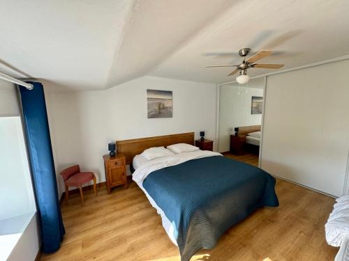 une chambre avec un lit et un ventilateur de plafond dans l'établissement Le Clos de la Bertillère, à Ambleville