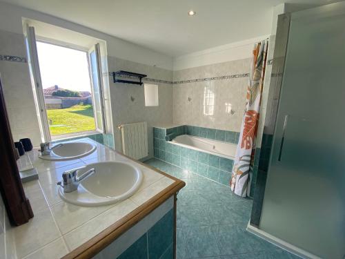 une salle de bain avec deux lavabos et une baignoire dans l'établissement Le Clos de la Bertillère, à Ambleville