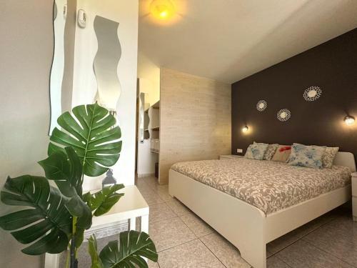 sypialnia z łóżkiem i rośliną w obiekcie Palm Garden Apartment w mieście Morro del Jable