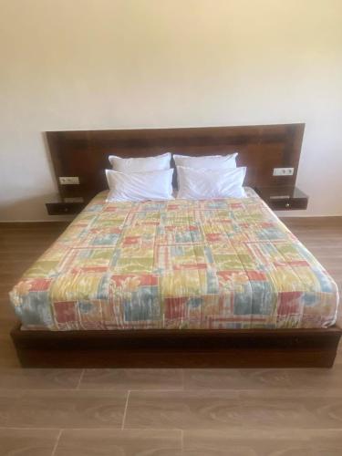 a bed with a colorful comforter in a room at Villa Tizra - Guest house in AÃ¯n el Ksob