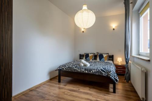 a bedroom with a zebra print bed with a chandelier at 32 Gdynia Oksywie - Apartament Mieszkanie dla 4 os in Gdynia
