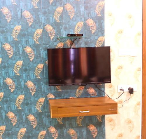 a flat screen tv sitting on top of a dresser at Hotel Midtown Inn in Trimbak