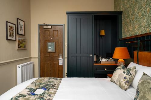 a bedroom with a bed and a desk and a door at Himley House by Chef & Brewer Collection in Himley