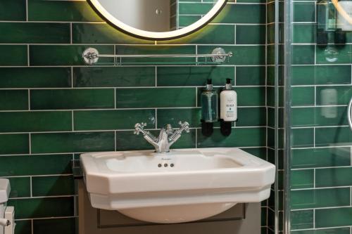 a green tiled bathroom with a sink and a mirror at Himley House by Chef & Brewer Collection in Himley