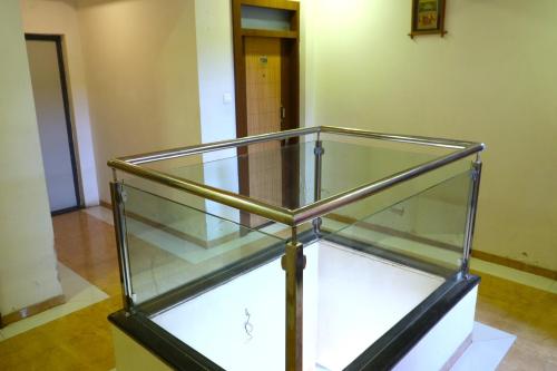 a glass case with a wooden pole in a room at Hotel Midtown Inn in Trimbak
