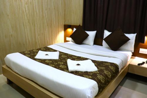 a bedroom with a large bed with two pillows at Hotel Midtown Inn in Trimbak