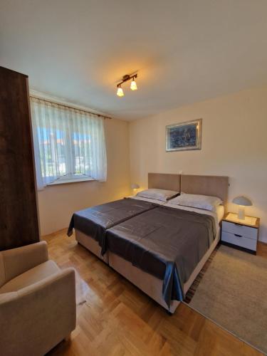 a bedroom with a large bed and a chair at Apartments Simag in Banjole